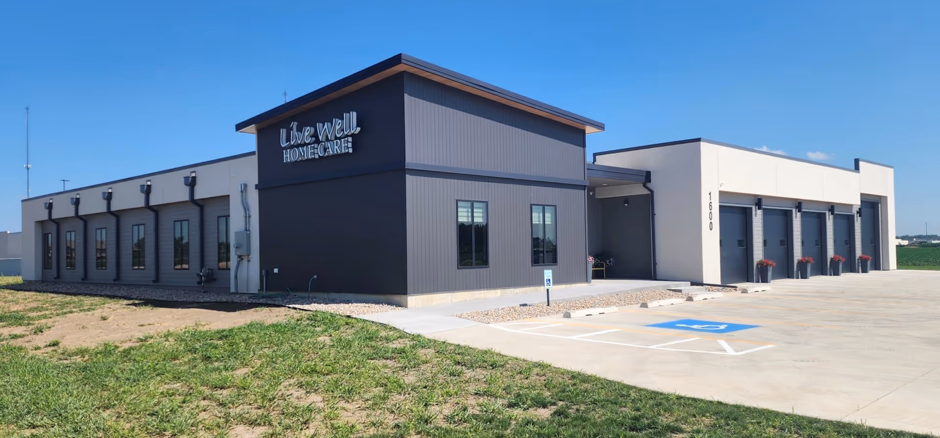 Exterior view of Live Well Home Care building with parking and blue sky.