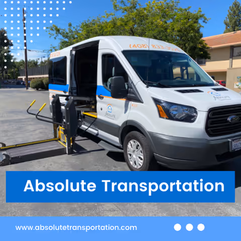 White wheelchair-accessible transport van with a ramp, branded Absolute Transportation, in a parking lot.