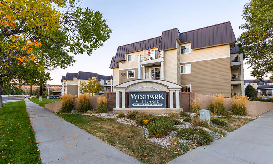 Front view of Westpark Village senior living building with landscaped entrance and sign.