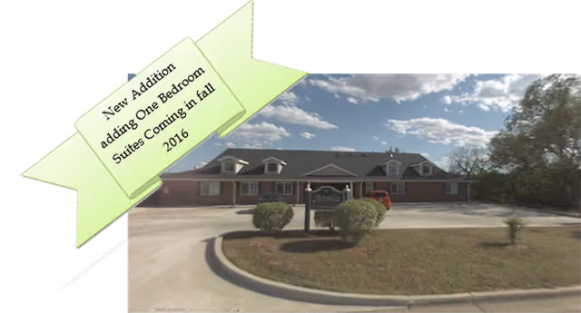 Exterior of Avonlea Cottage of Shawnee with driveway, front sign, and new addition banner.