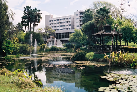 A Fredericka Manor Care Center sits behind a landscaped pond with fountains and a gazebo.