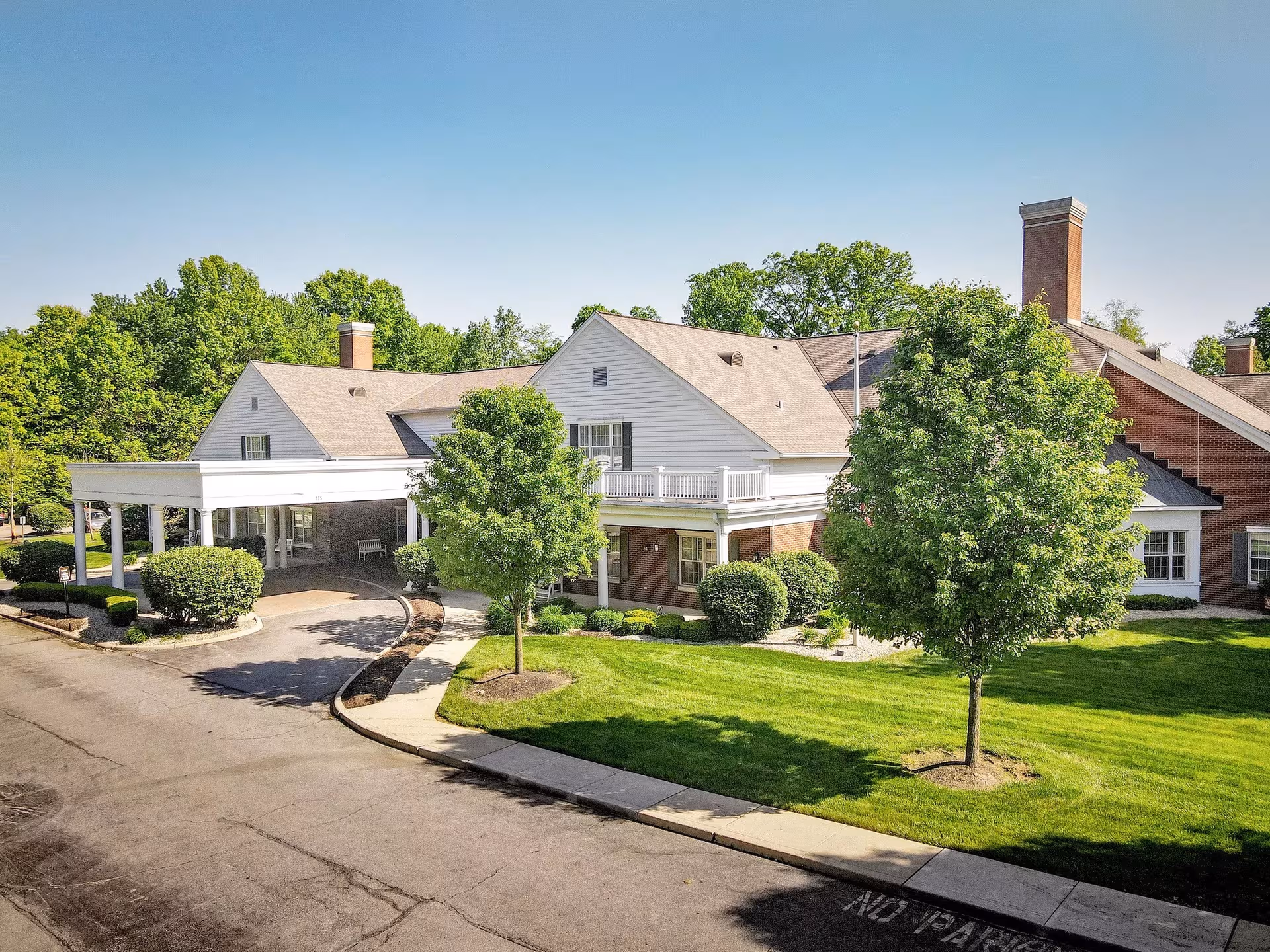 Exterior view of StoryPoint Gahanna Central with green lawn, trees, and driveway.