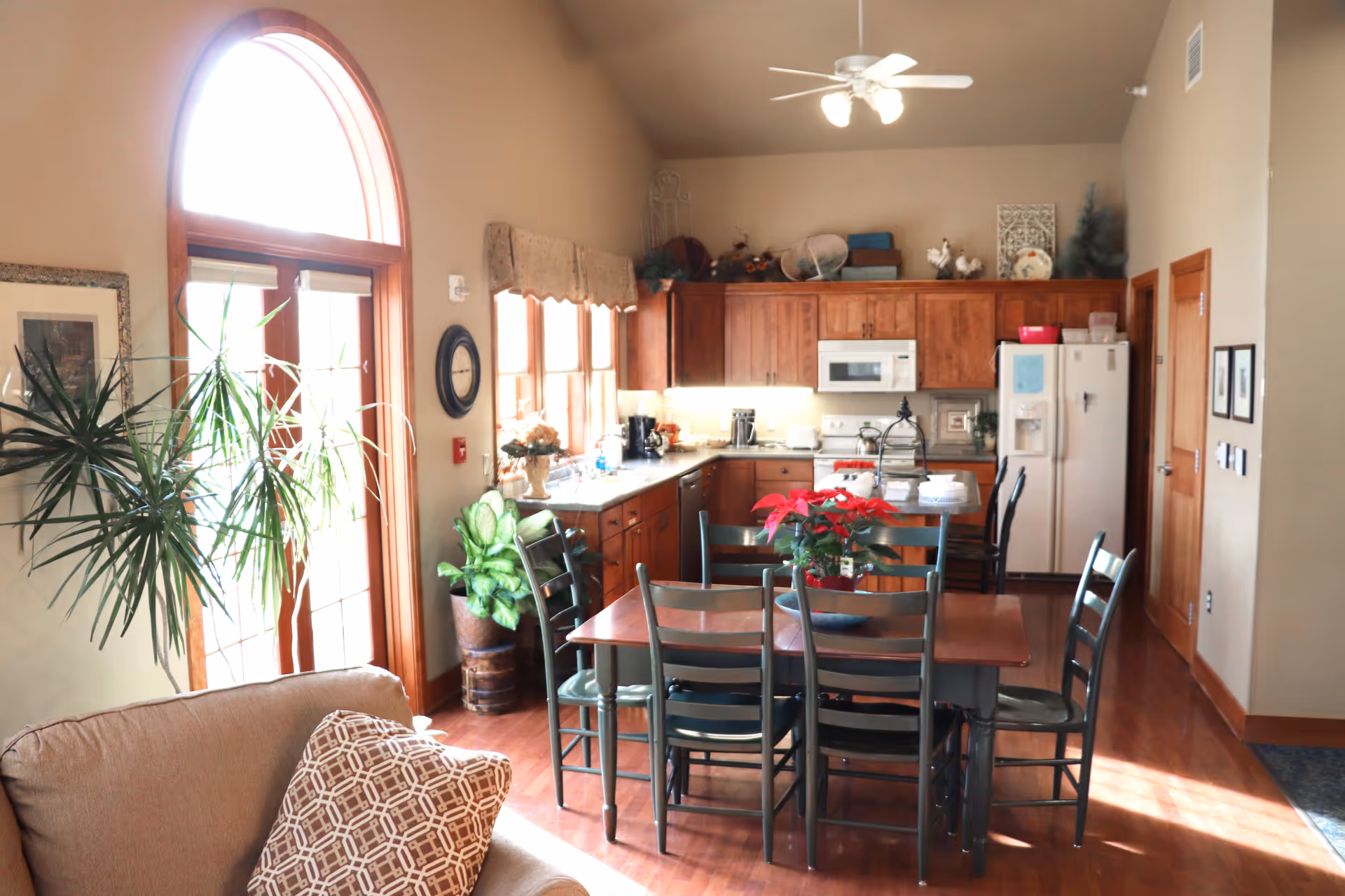 Open dining area with a wooden table, metal chairs, and a full kitchen.