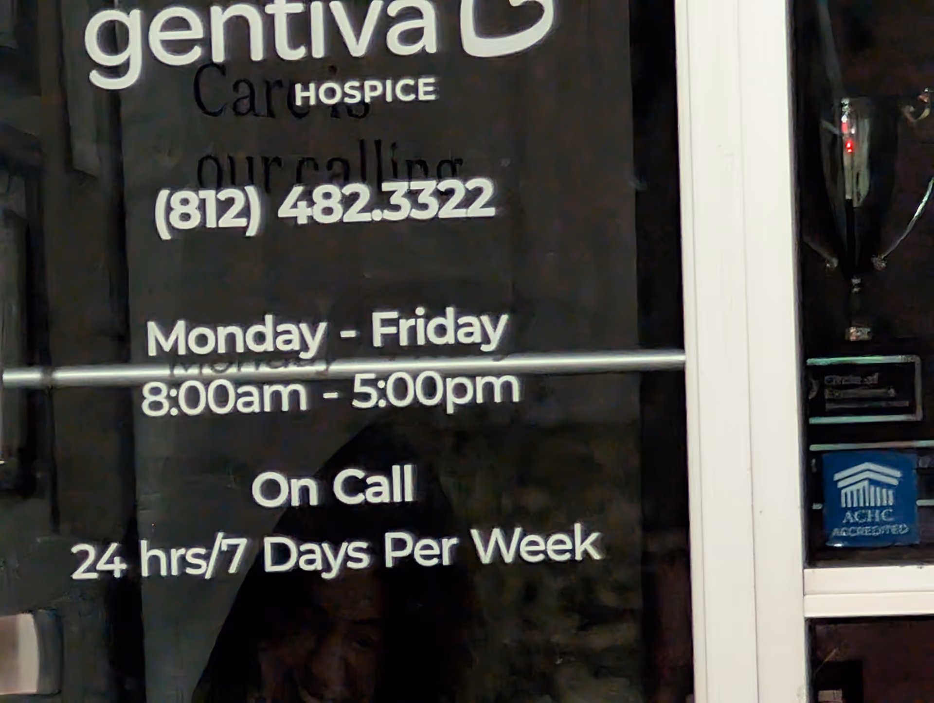 Glass door displaying Gentiva Hospice signage, contact number, and business hours.