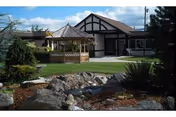 Front view of Prescott Manor Nursing Home with gazebo, lawn, and landscaped rocks.