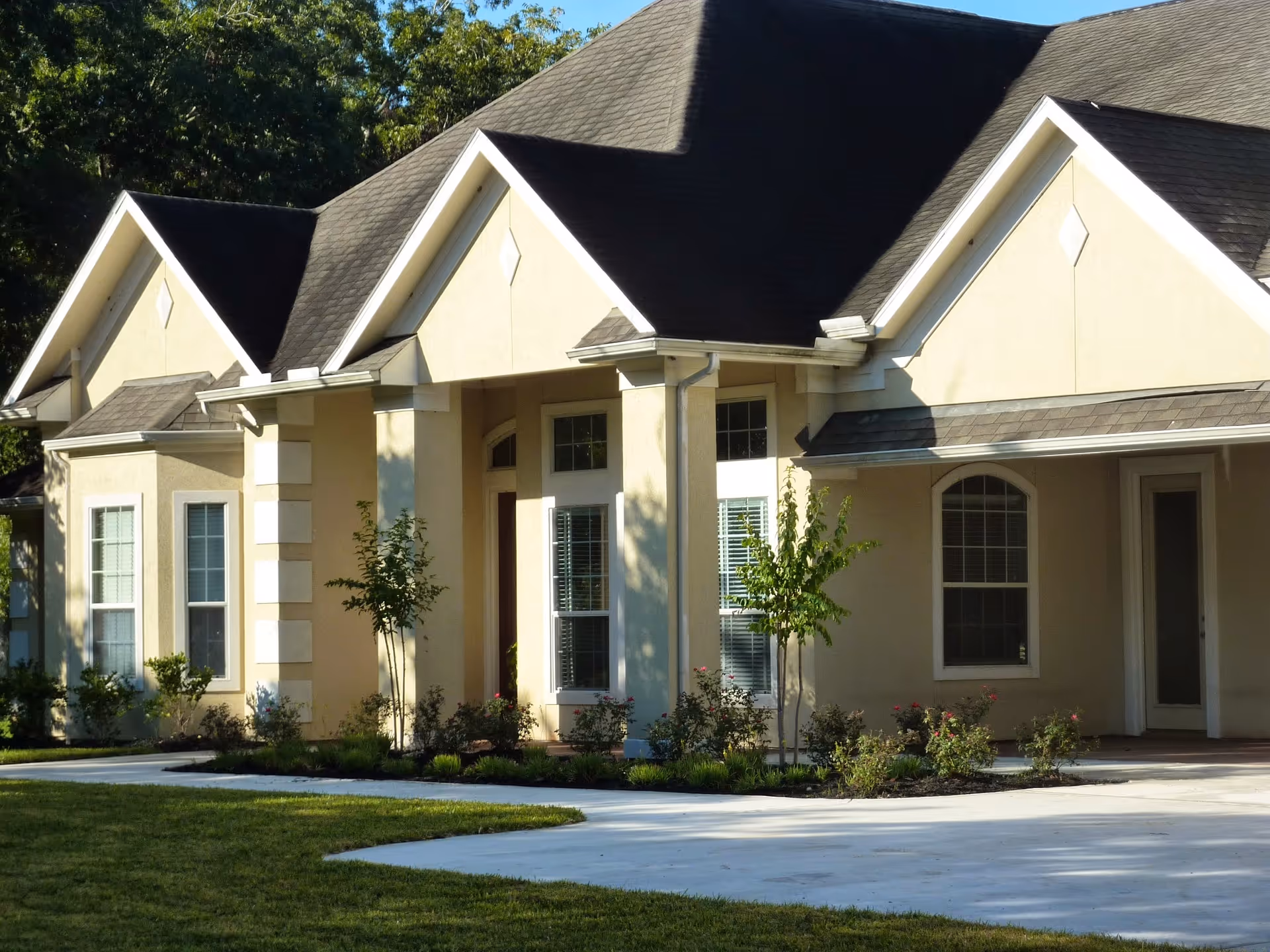 A beige senior living facility, Casa de Nuez, with peaked roofs, front entrance, and landscaped lawn.