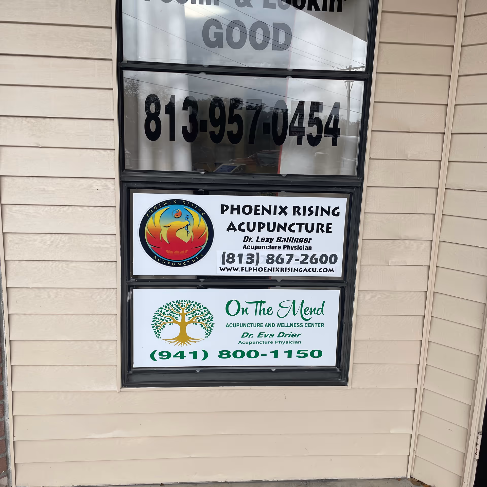 Exterior window signs advertise two acupuncture clinics and phone numbers.