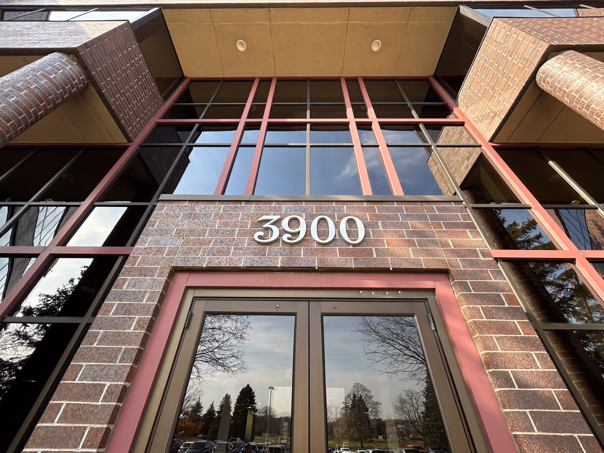 Front exterior of a brick building with large glass windows and the number 3900