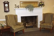 Two striped armchairs flank a white mantel fireplace in a cozy living room.