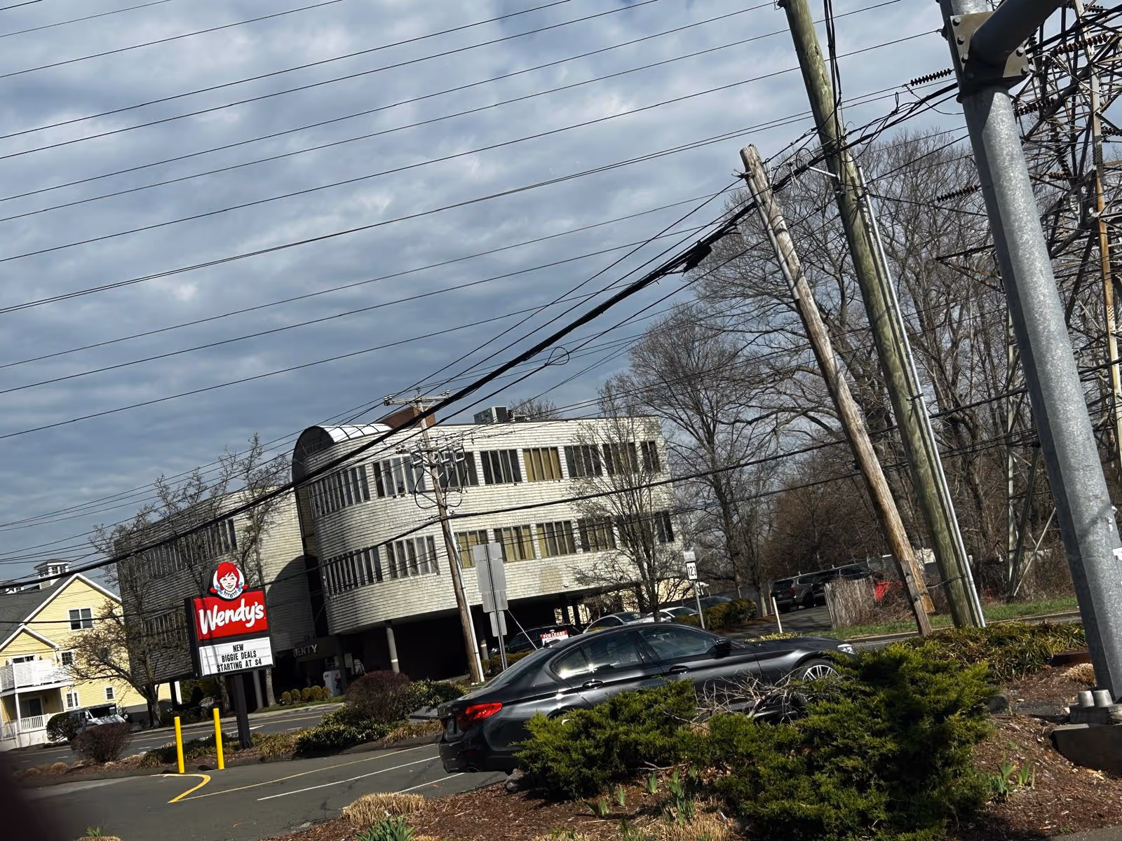 Exterior view of a curved building with a Wendy's sign in the parking lot.