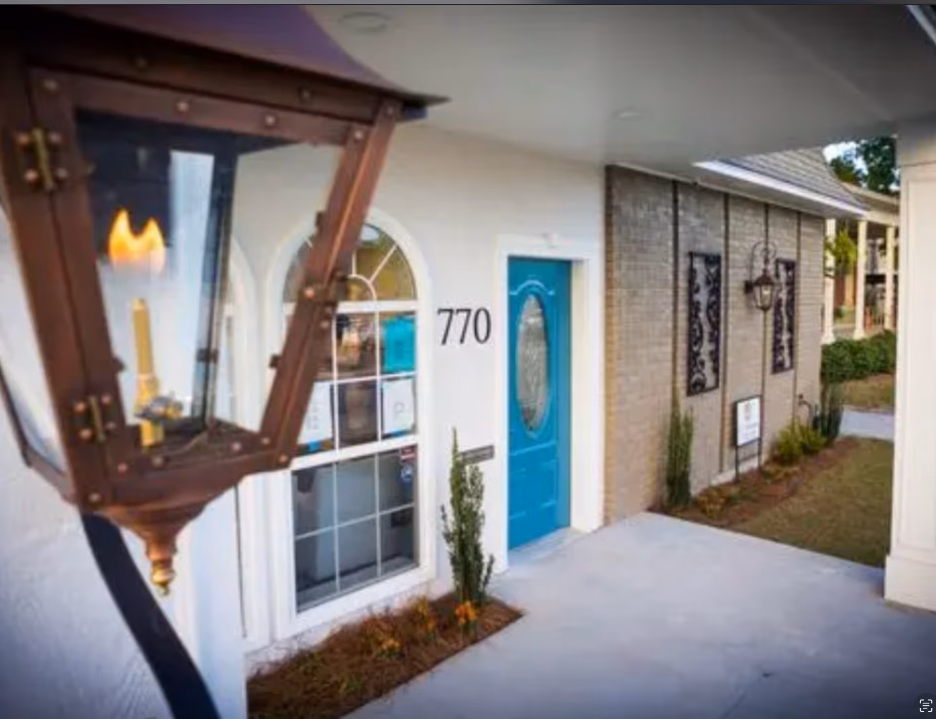 Exterior view of facility entrance with blue door and arched window
