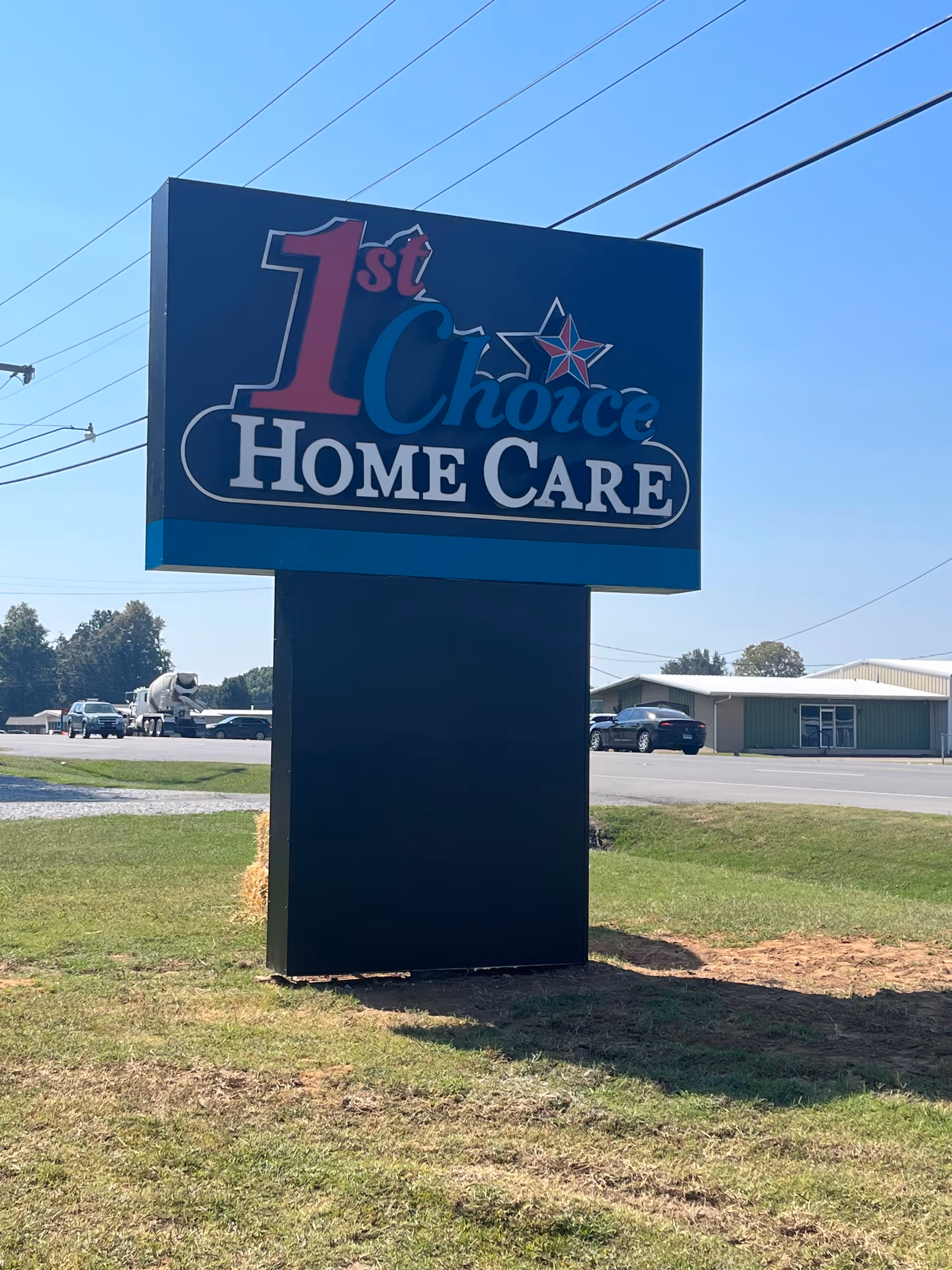 Large blue outdoor sign for 1st Choice Home Care near a building