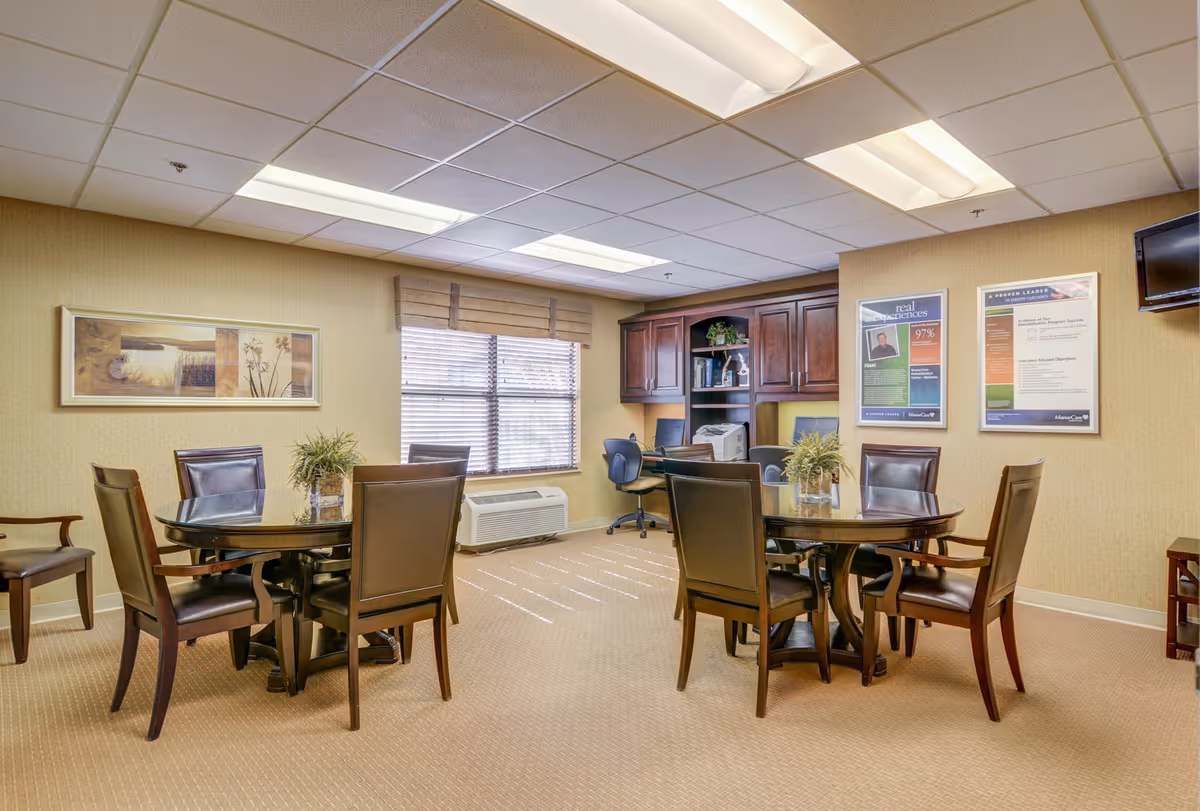 Interior common dining area with round tables, chairs, and wall posters.