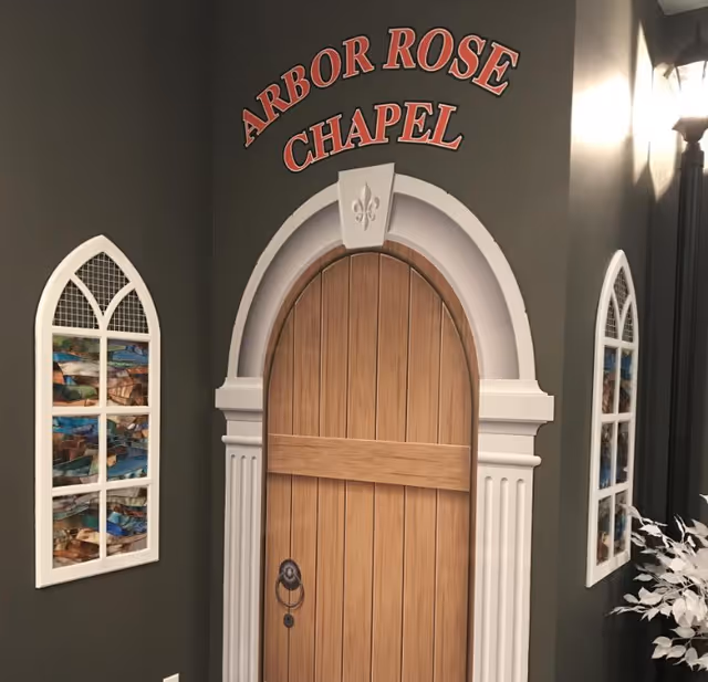 Interior feature of Arbor Rose Chapel with a wooden arched door and decorative frames.