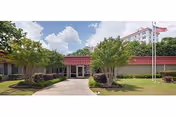 Exterior view of PruittHealth Augusta building entrance with red awning and flag.