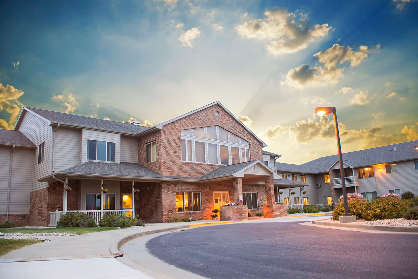 Exterior view of a senior living facility with brick facade and main entrance.