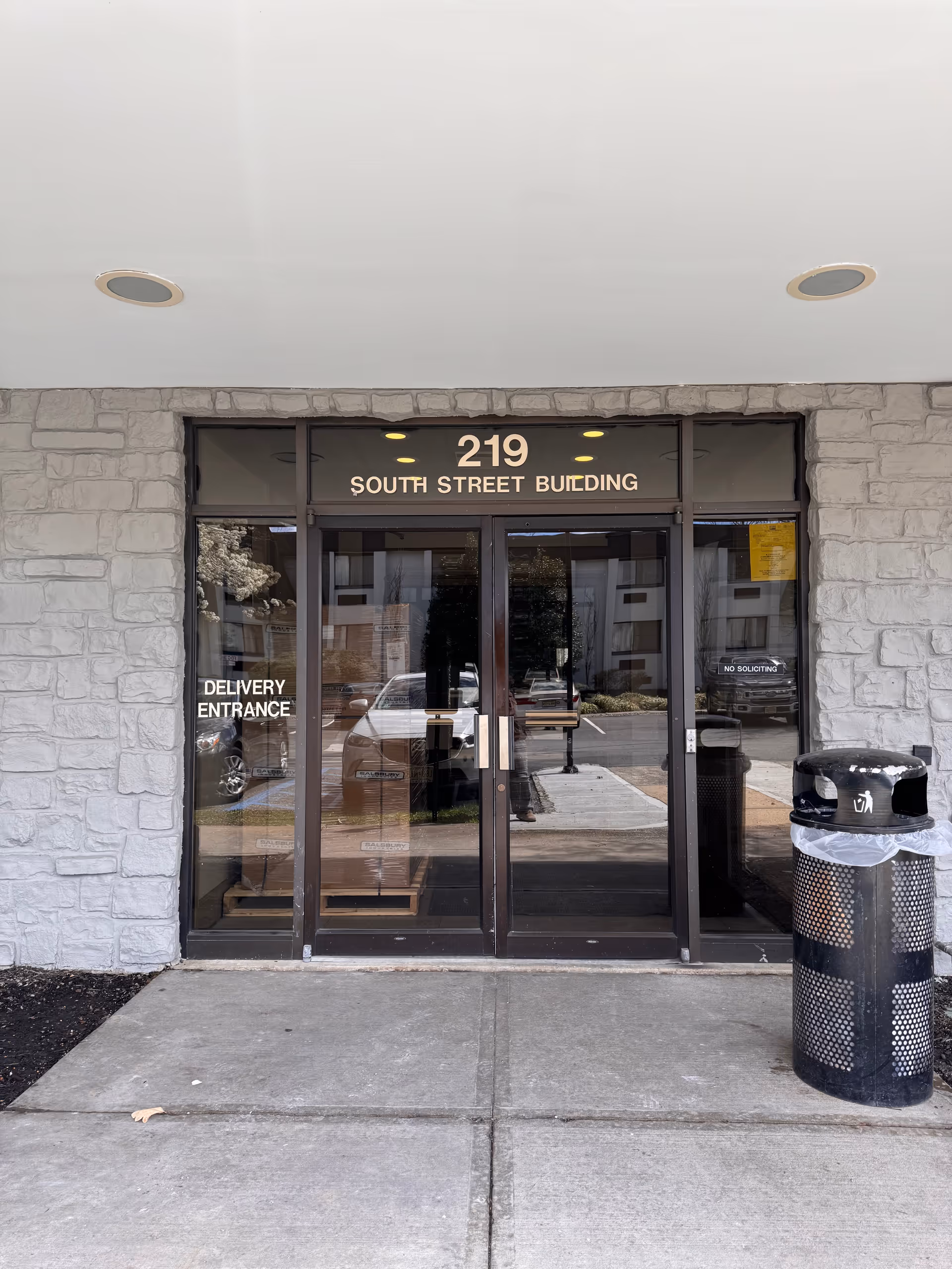 Glass doorway with stone facade showing 219 South Street Building above.