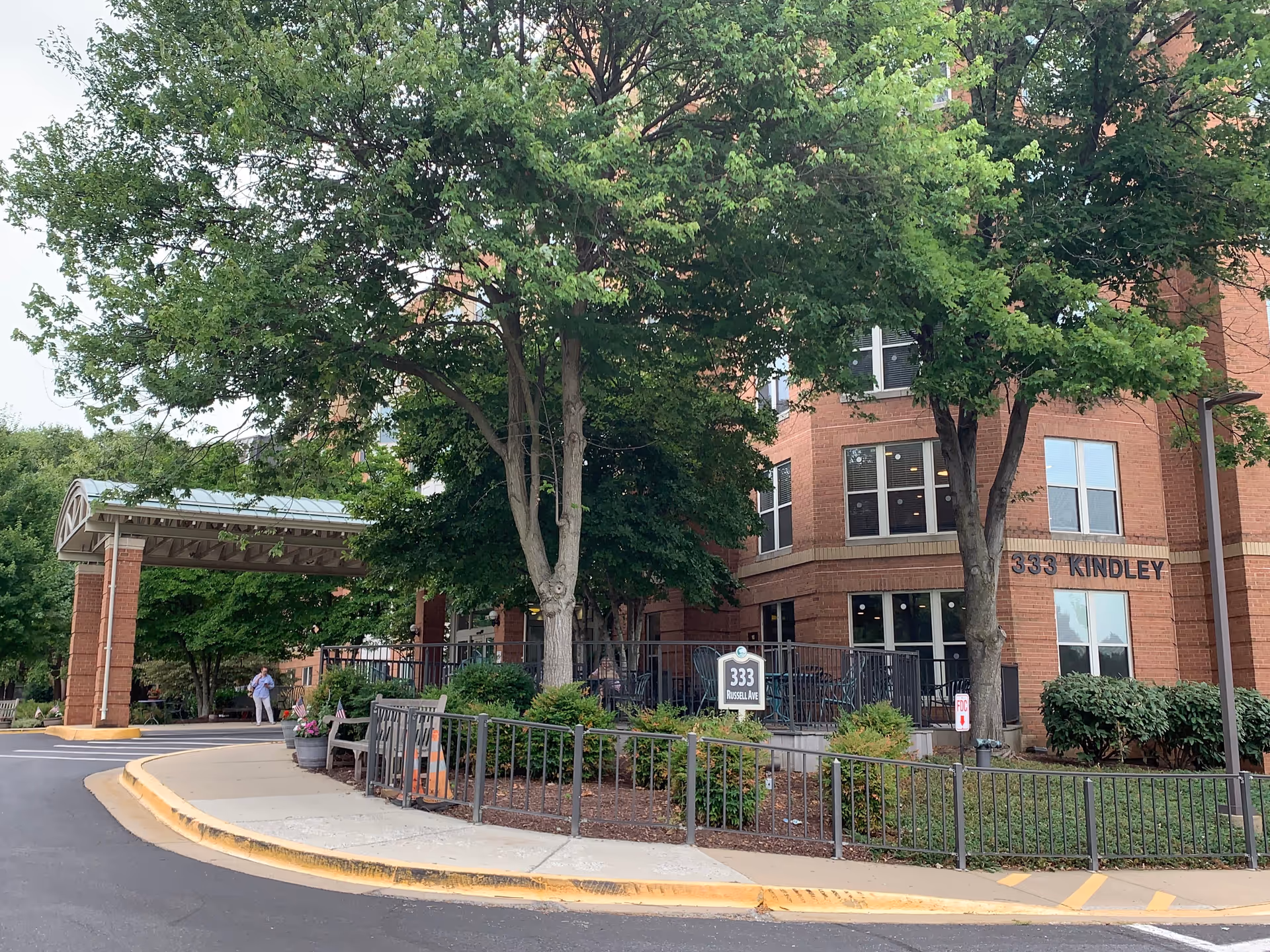 Exterior view of Kindley Assisted Living building with trees, walkway, and entrance.