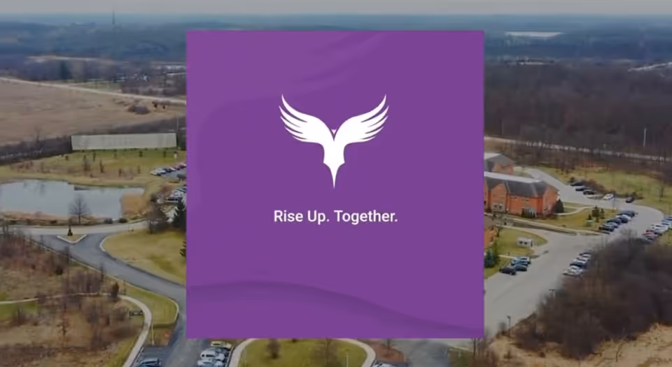 Aerial view of a senior living campus with a purple promotional graphic featuring a white bird.