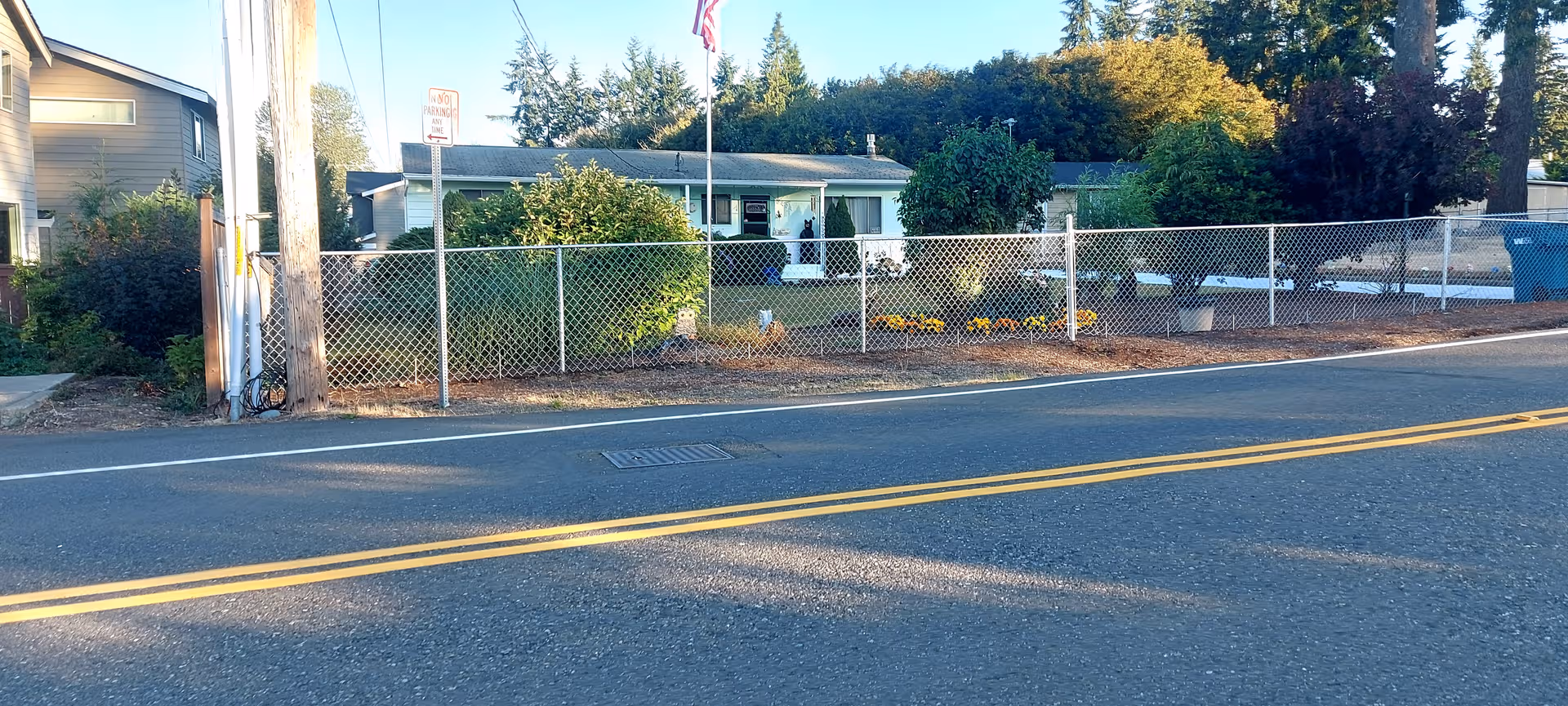 Exterior of a single-story facility behind a chain-link fence along a street.