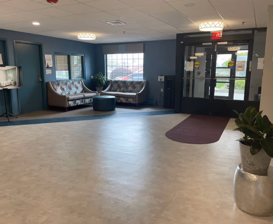 Pawtucket Center lobby with teal walls, couches, potted plants, and glass entry doors.