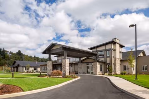 Exterior view of Salem Transitional Care entrance with driveway, landscaping, and covered drop-off.