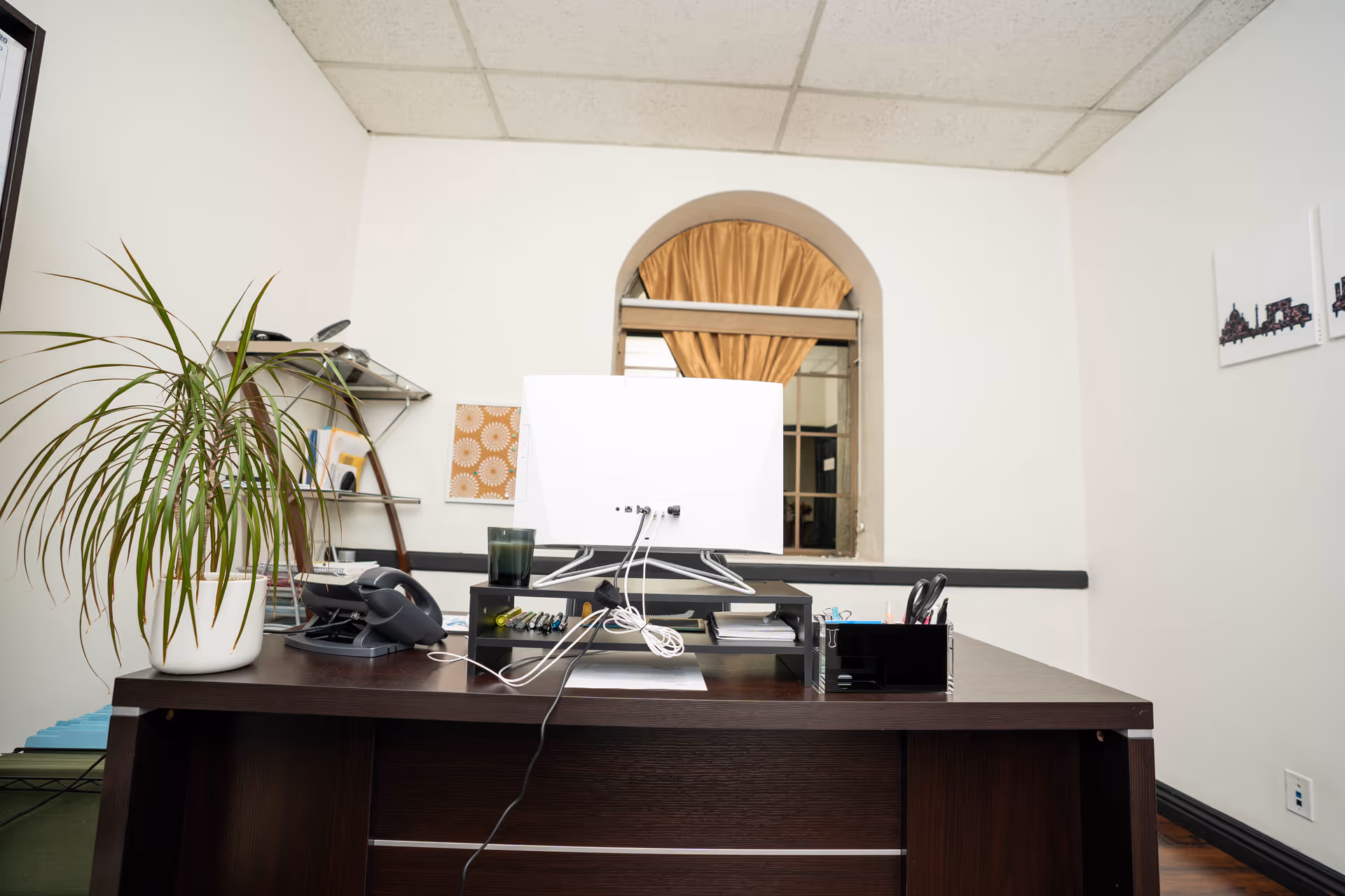 Office desk with computer, plant, and organized workspace in a Faith In Angels Hospice interior
