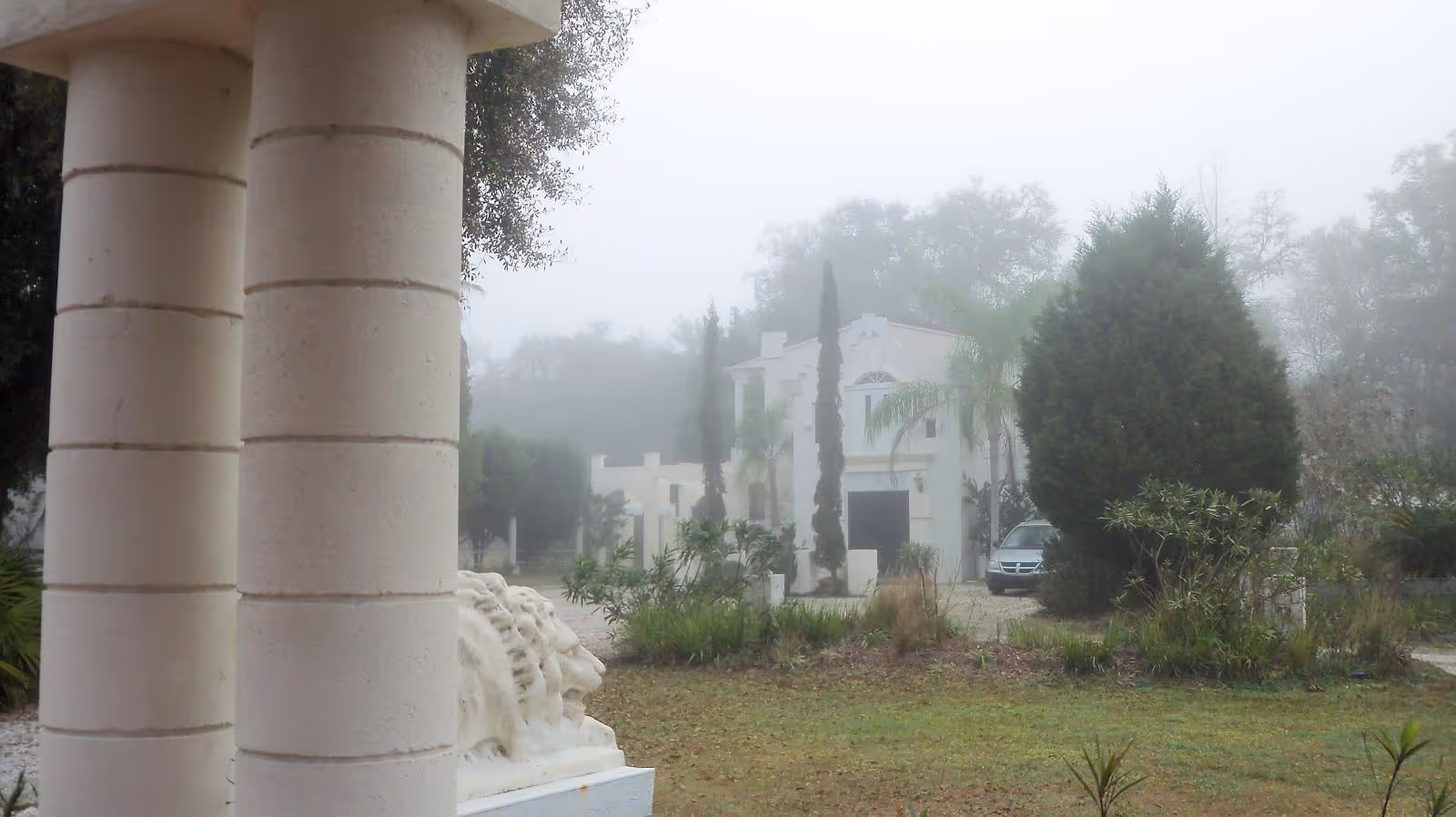Foggy exterior view of The Hacienda House senior living facility with columns