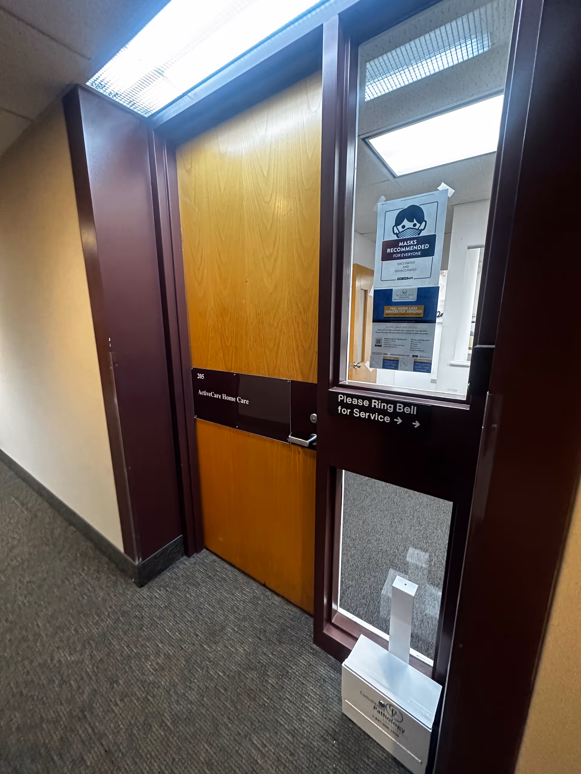 Interior hallway with a wooden door labeled ActiveCare Home Care and a service bell.