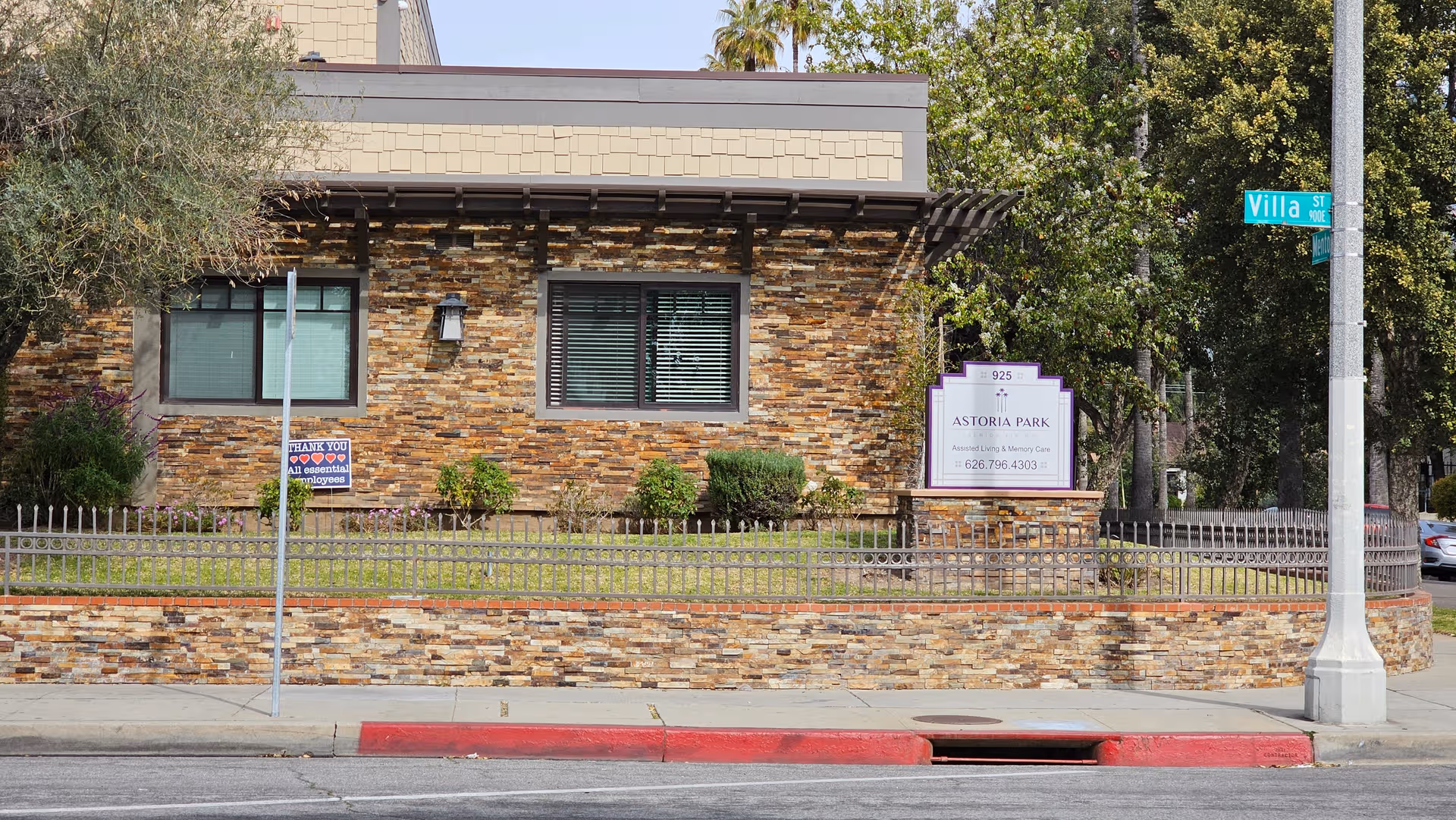Front view of Astoria Park Senior Living facility featuring stone exterior and sign.