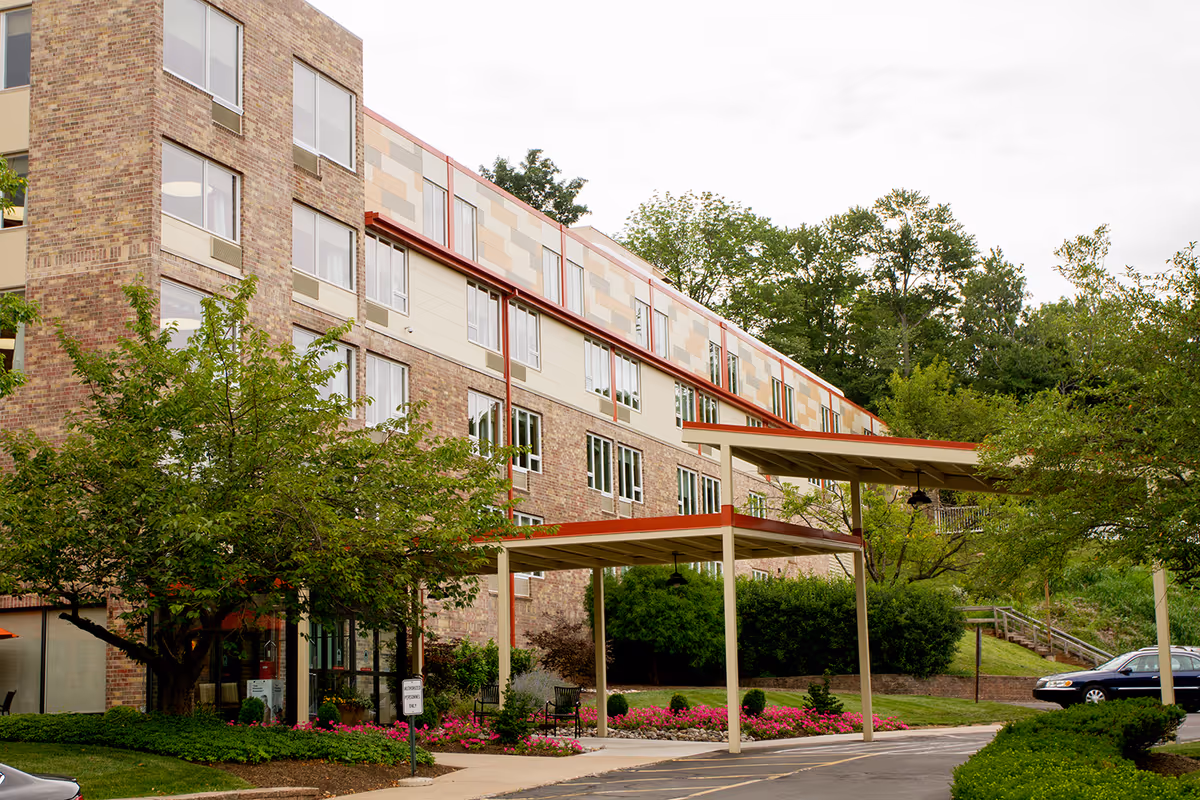 Exterior view of Pine Run Village Health Center, a multi-story brick senior living facility.