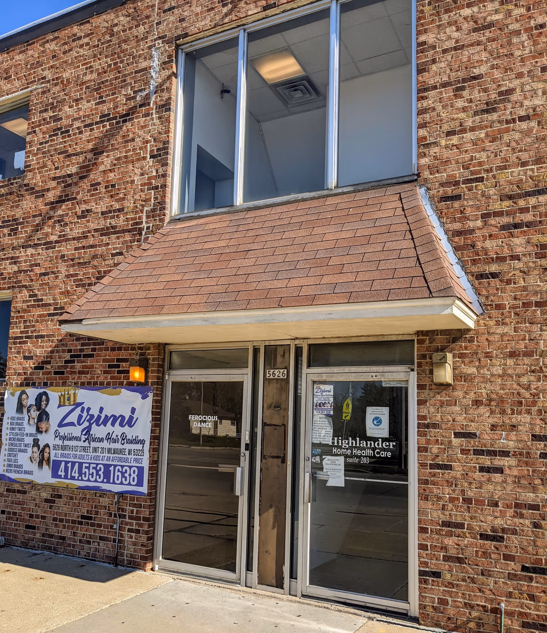Brick building entrance with glass doors and Highlander Home Health Care sign