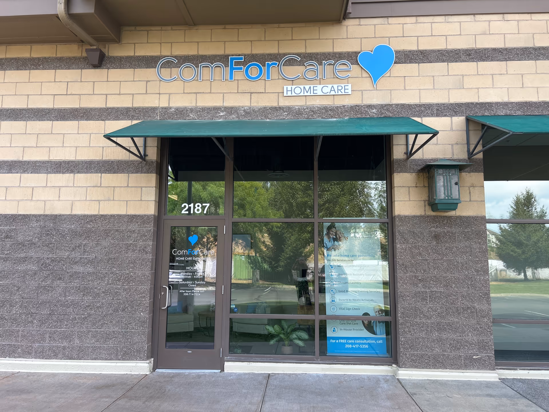 Front exterior of ComForCare Home Care with glass entrance, green awnings, and signage.