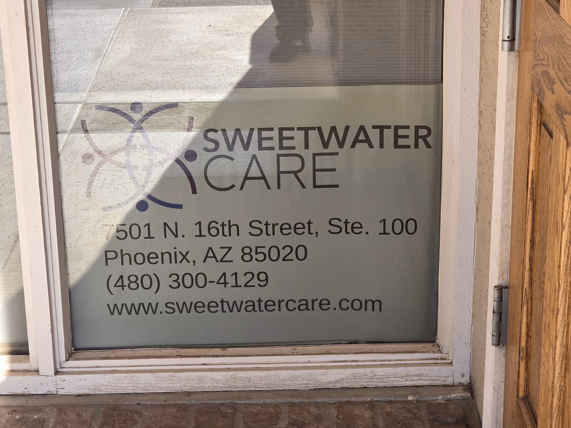Glass storefront window displaying the Sweetwater Care logo and address.
