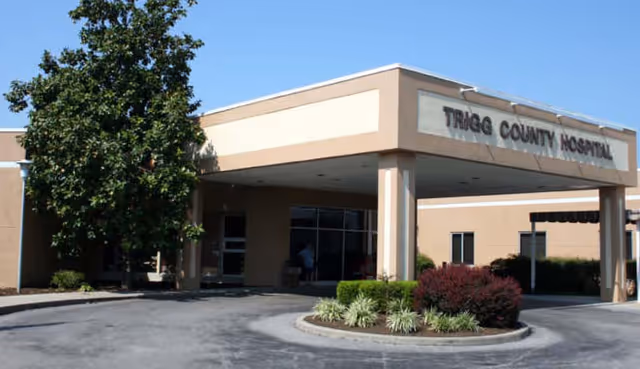 Front entrance of Trigg County Hospital with driveway, landscaping, and a covered walkway.