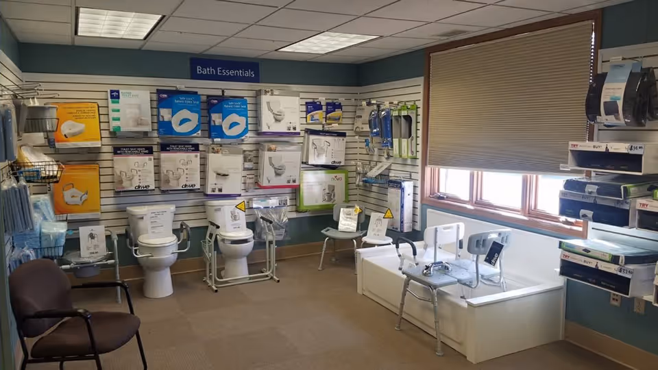 Interior display area with bathroom fixtures and toilets labeled Bath Essentials in a showroom.