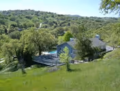 A blue Garden View Inn building sits on a lush hillside with trees.