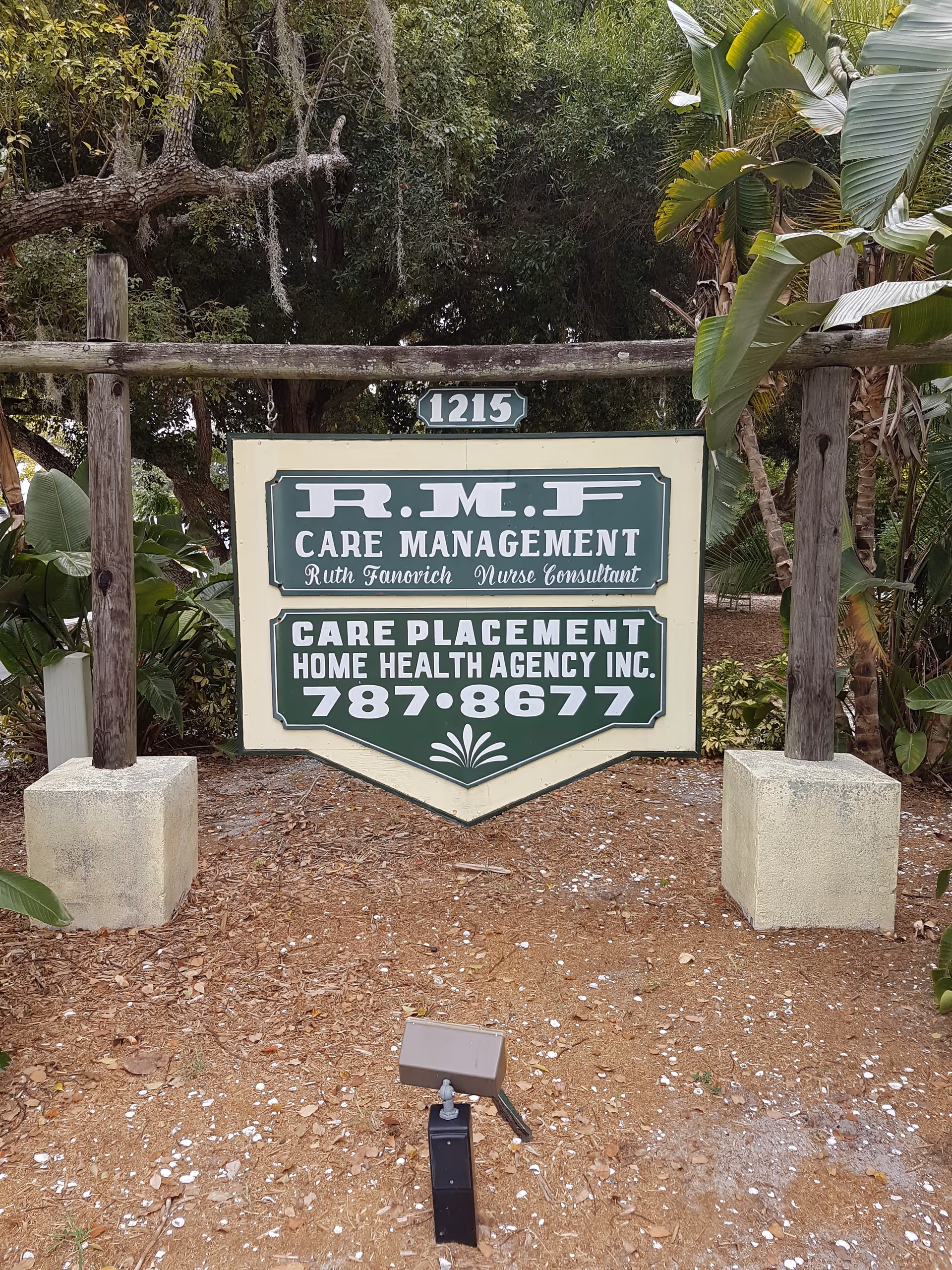 Exterior sign for Care Placement Home Health Agency surrounded by trees and landscaping.