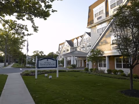 Exterior view of Atria Tanglewood with a manicured lawn and walkway.