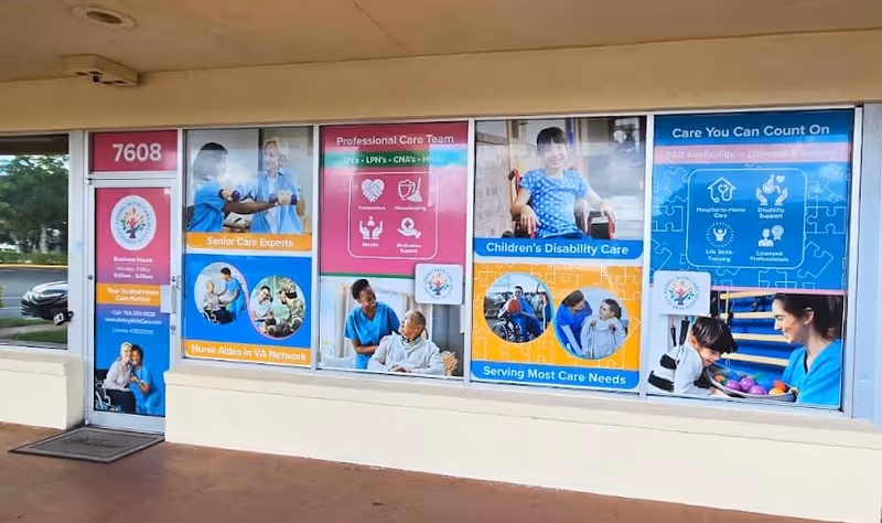 Colorful storefront windows advertise senior care services at Aiding With Care Health Services.