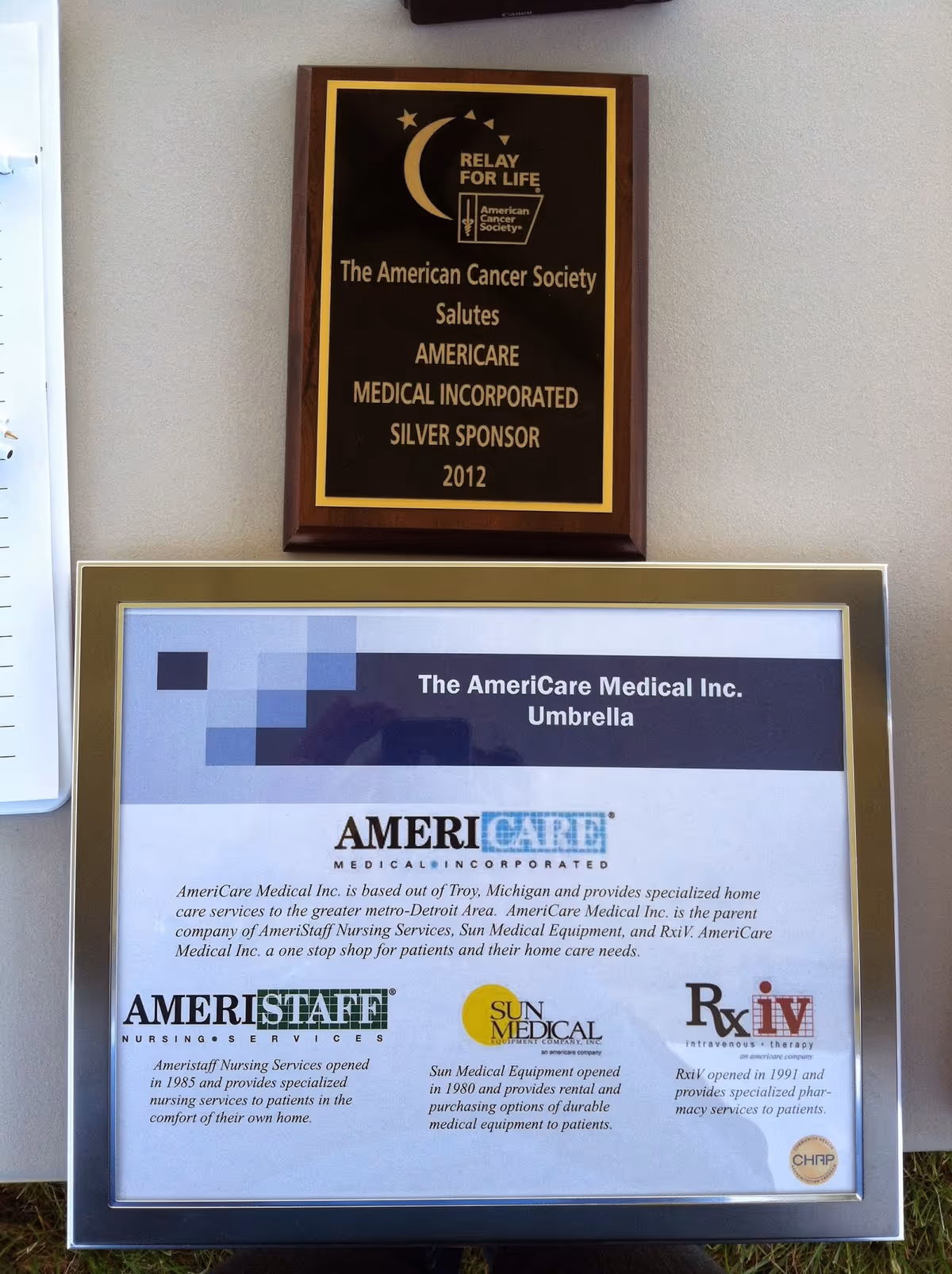 Two mounted plaques display AmeriCare Medical information on a light hallway wall.