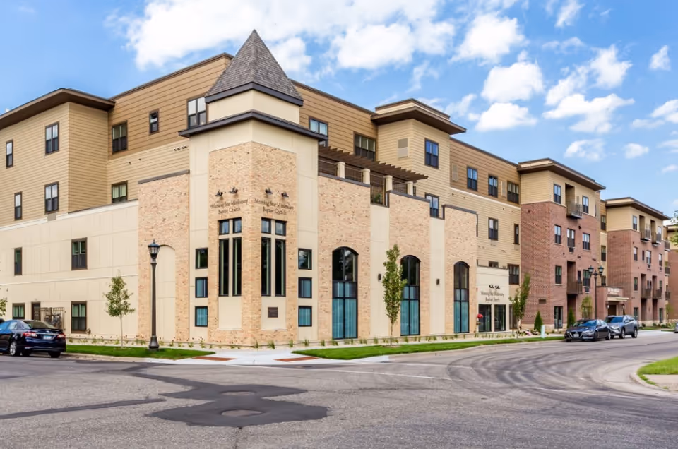Exterior view of a multi-story Seven Hills Senior Living building on a curved street.