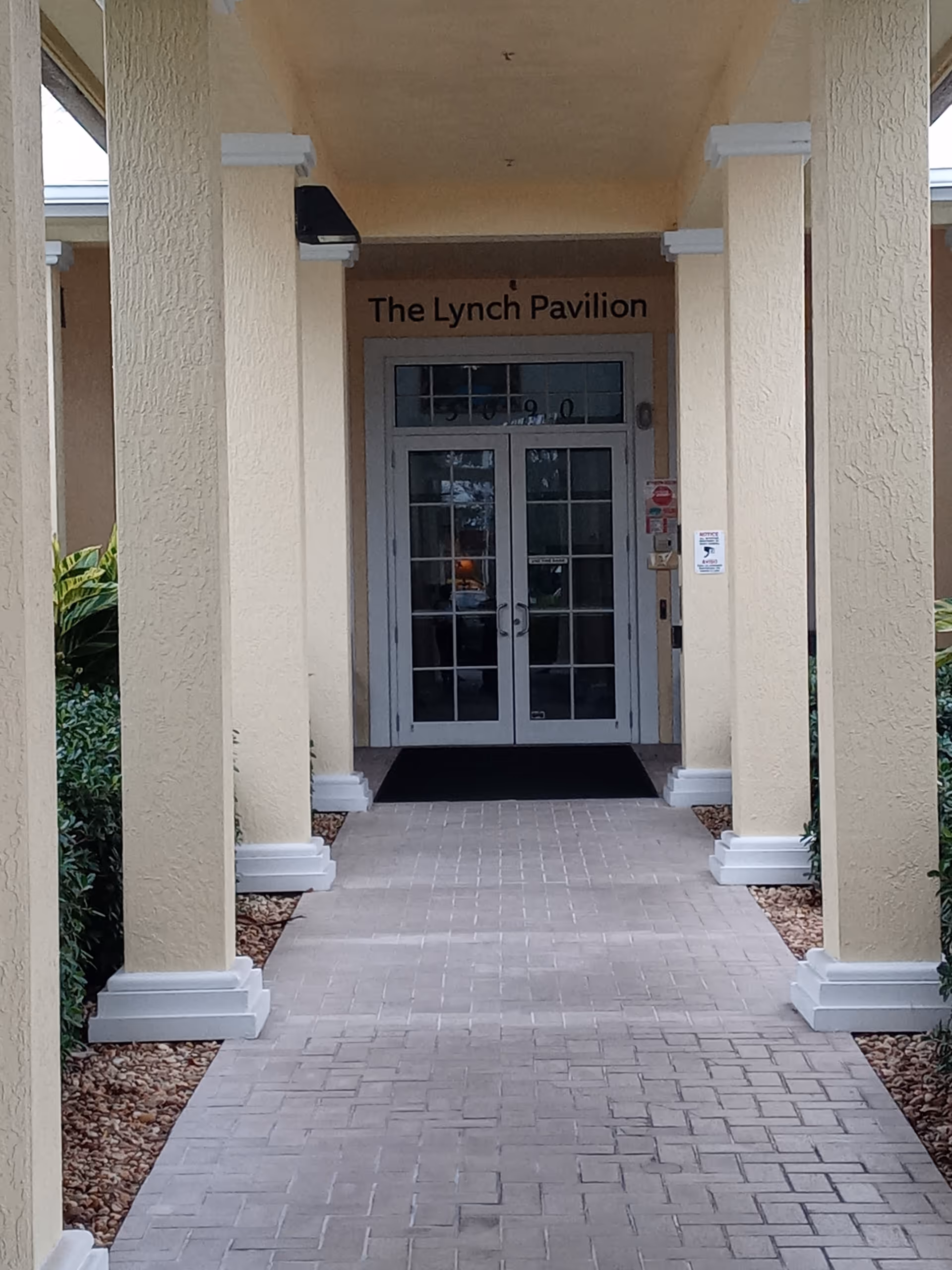 Entrance to The Lynch Pavilion with beige columns and glass double doors.