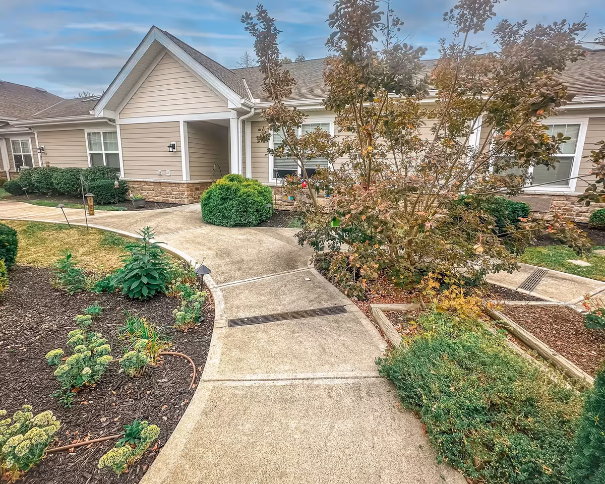 Front entrance of Pinebrook of Milford with curved walkway and landscaped shrubs.