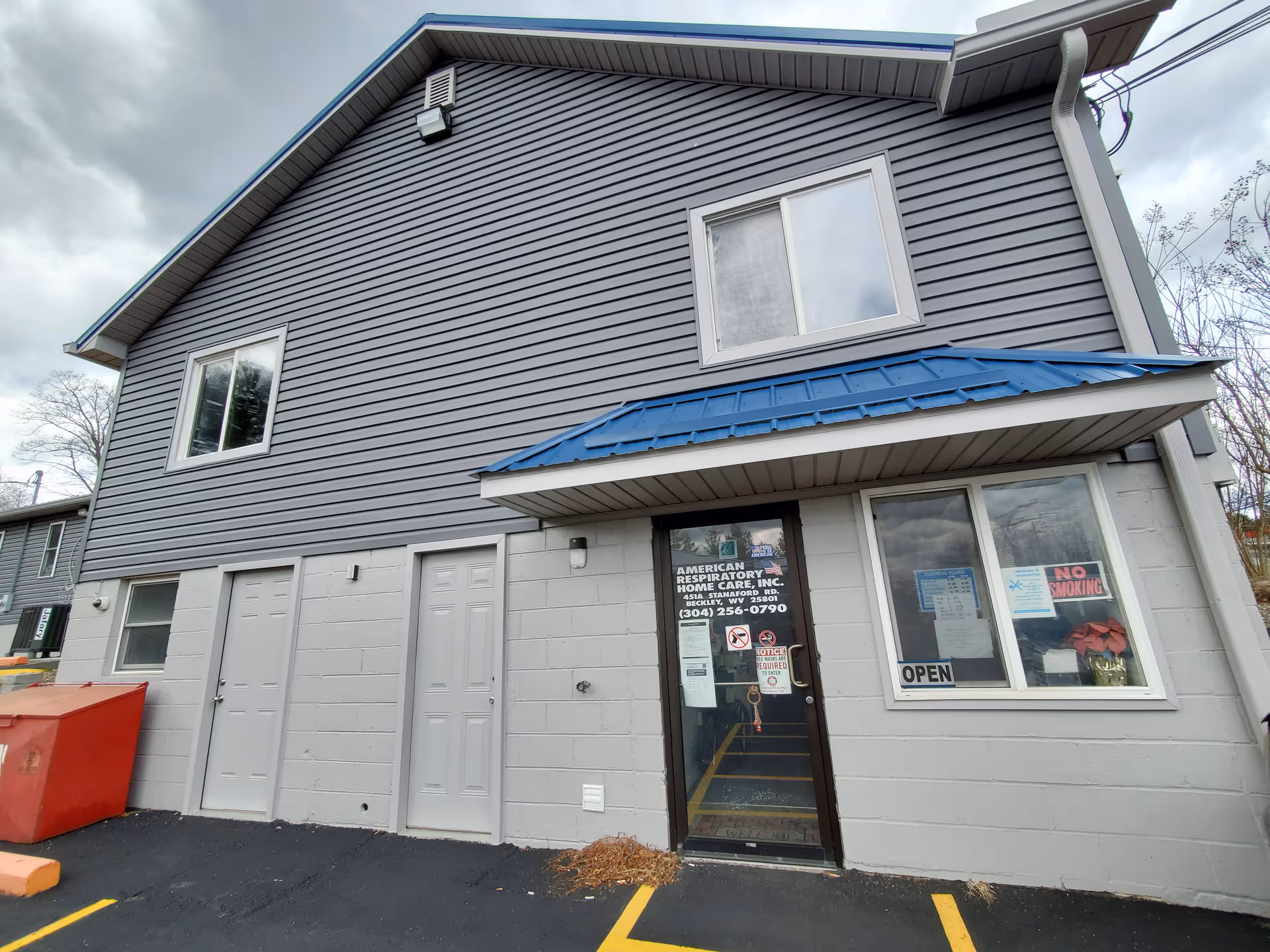 Two-story building exterior with storefront entrance labeled American Respiratory Home Care and a blue awning.