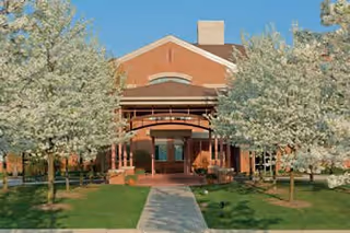 Front view of Fox Run Senior Living Community entrance with brick facade and trees.
