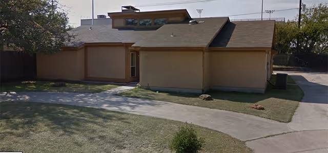 Exterior view of The Guardian senior living facility with beige walls and a driveway.