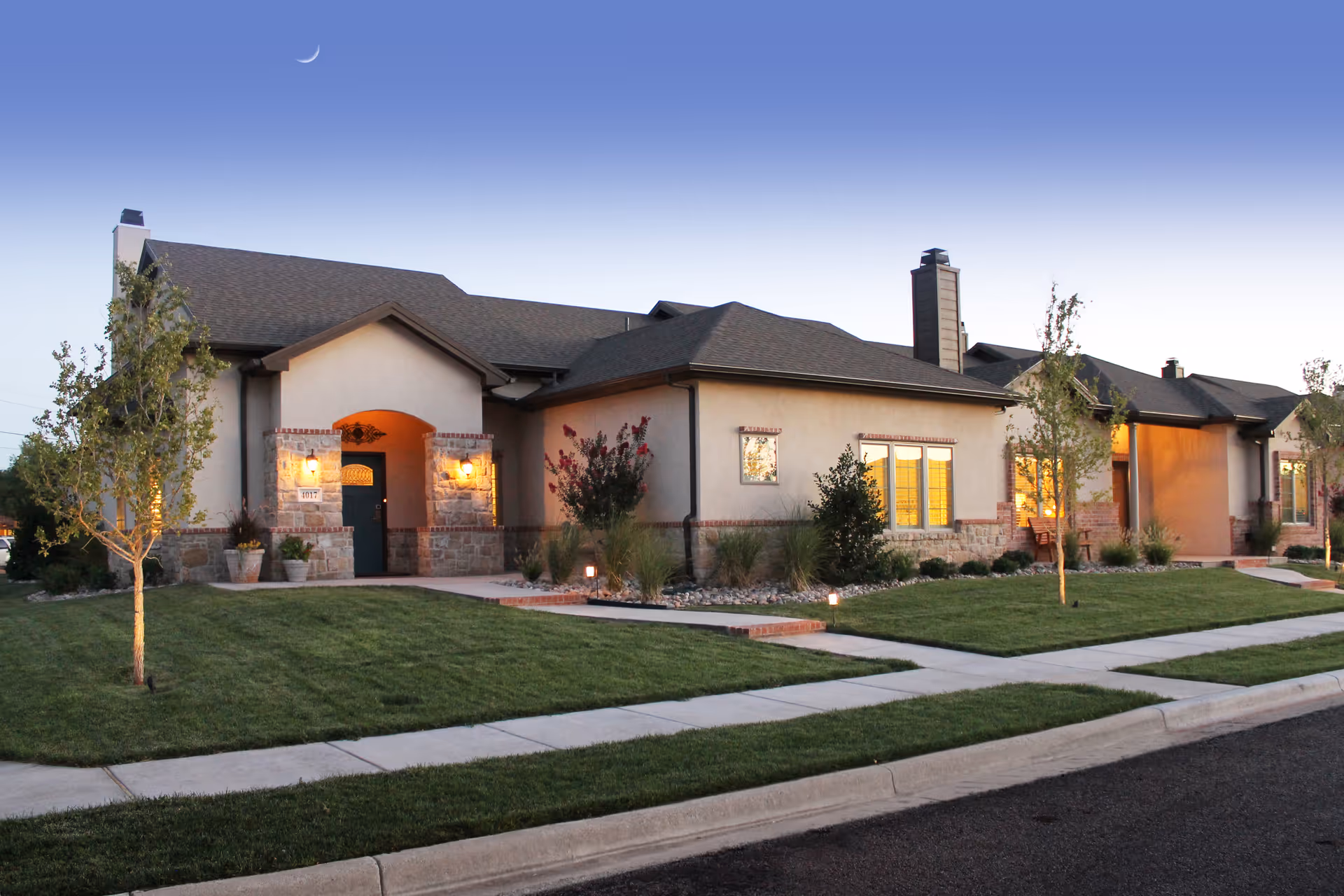 Front exterior of a single-story senior living facility with a manicured lawn.