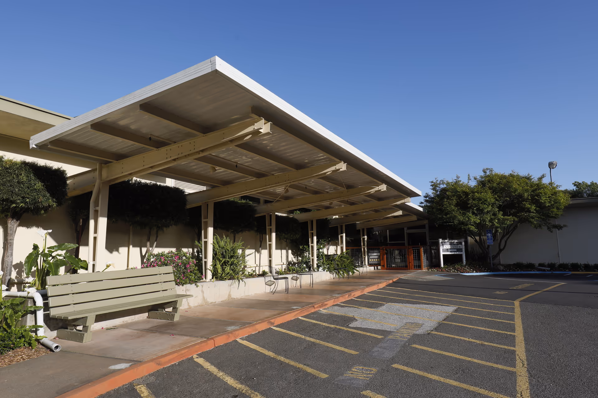 Exterior view of The Oaks Post Acute with a covered entrance and parking.