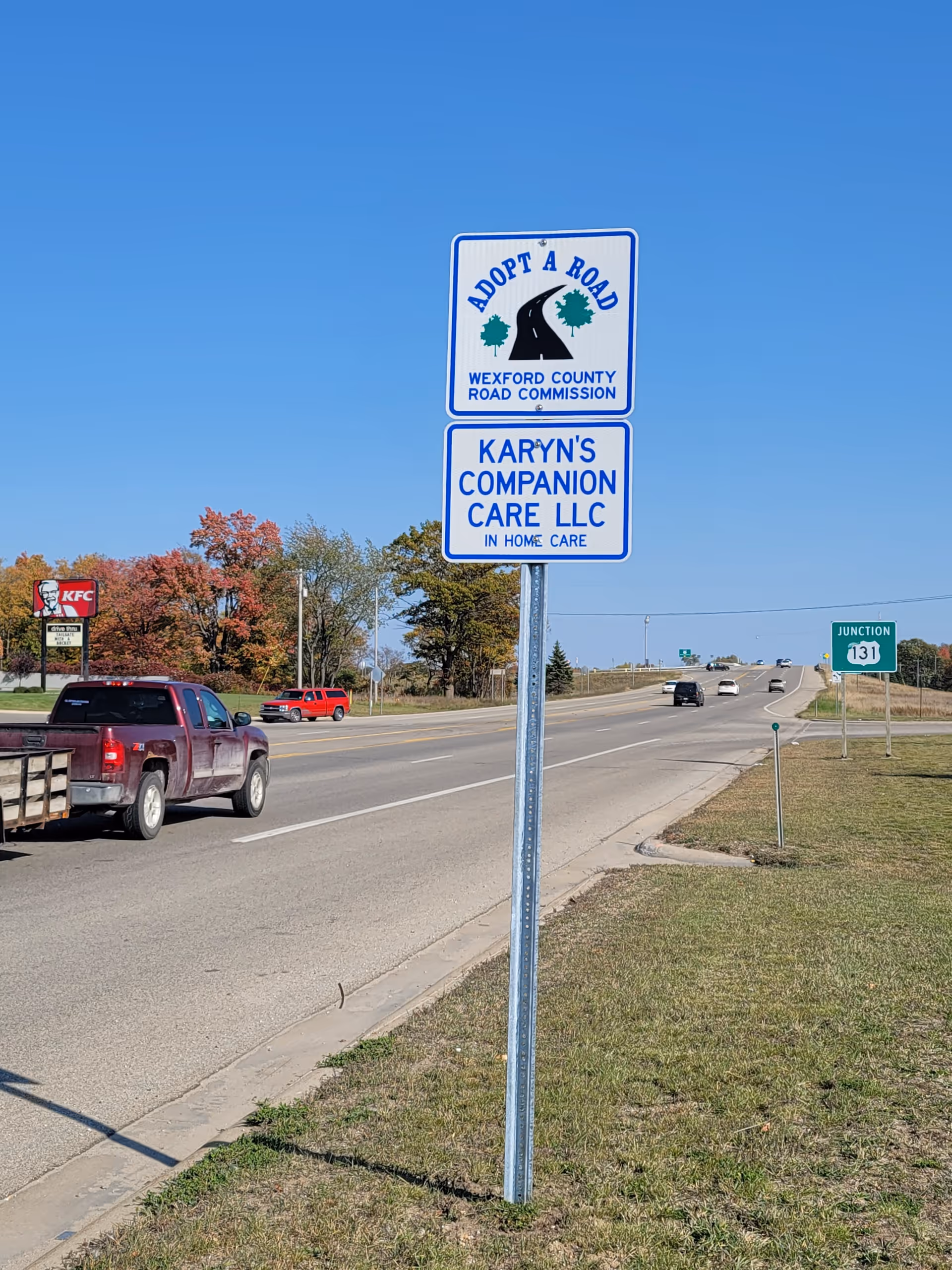 Tall roadside sign for Karyn's Companion Care LLC along a highway.
